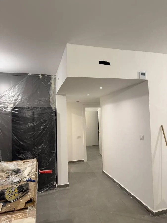 הנמכת תקרה בגבס צבועה בלבן עם ספוטים וחלל מעבר
